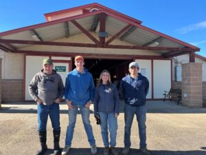 Four people stand outside a building