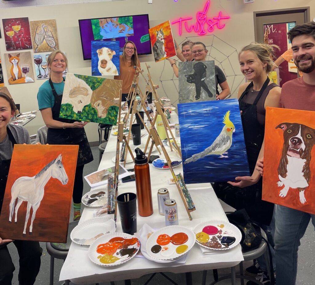 a group of people pose with their paintings