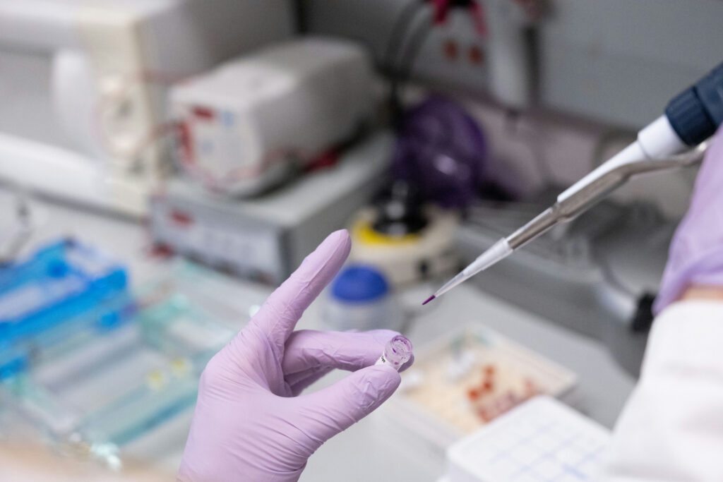 hand holding pipette going into test tube
