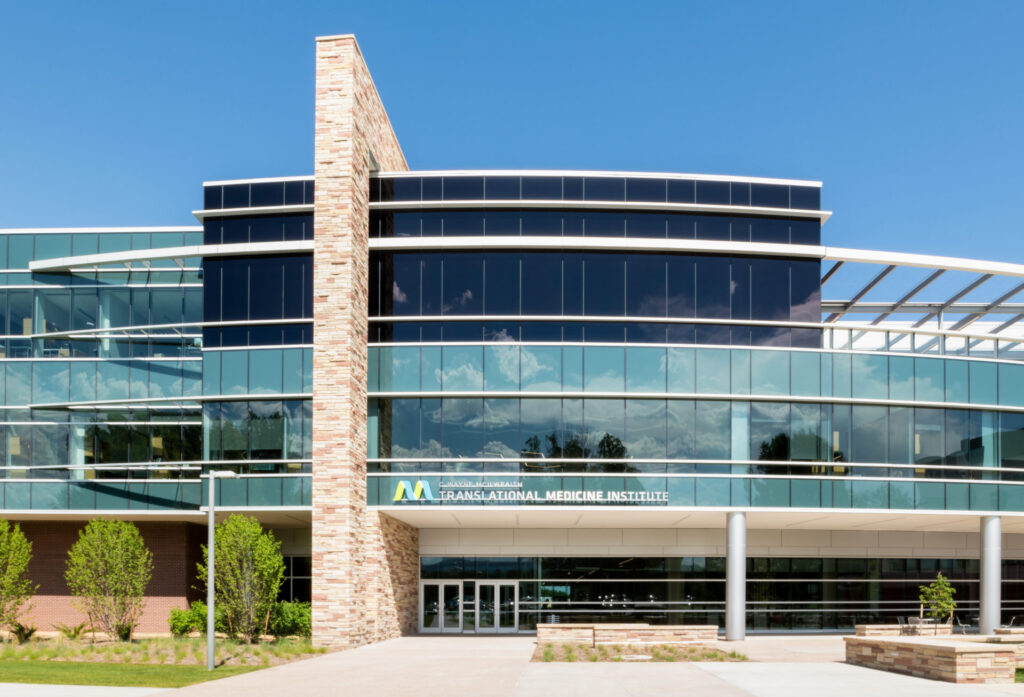 The front entrance of a modern glass and stone building labeled “Translational Medicine Institute.”
