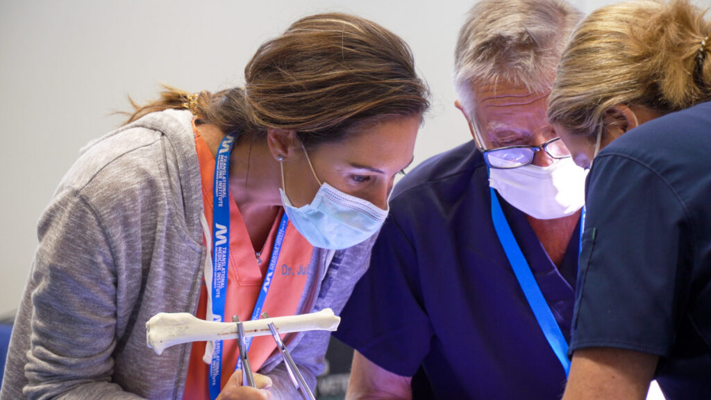 three people wearing masks looking down