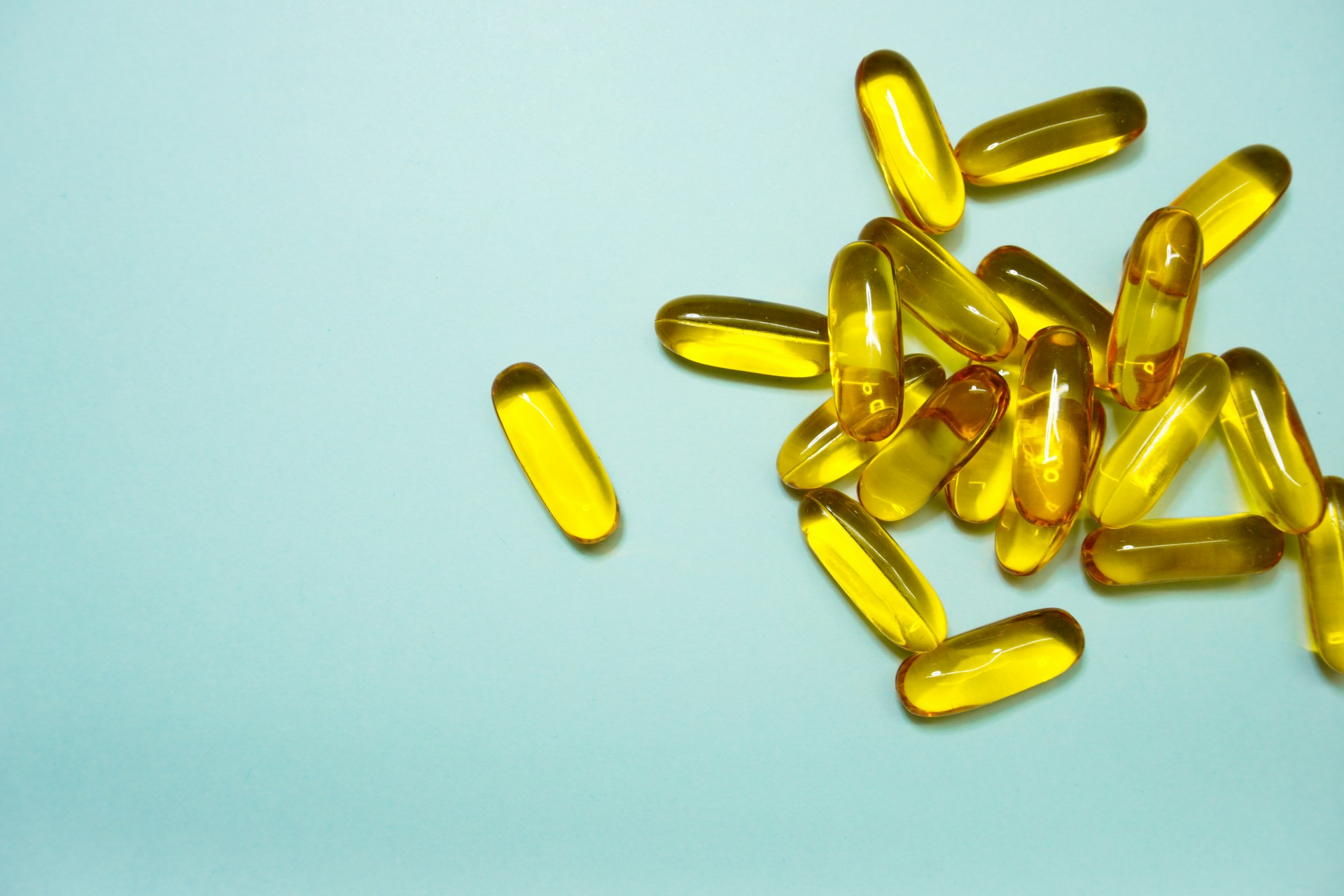 a close up of fish oil pills on a green background