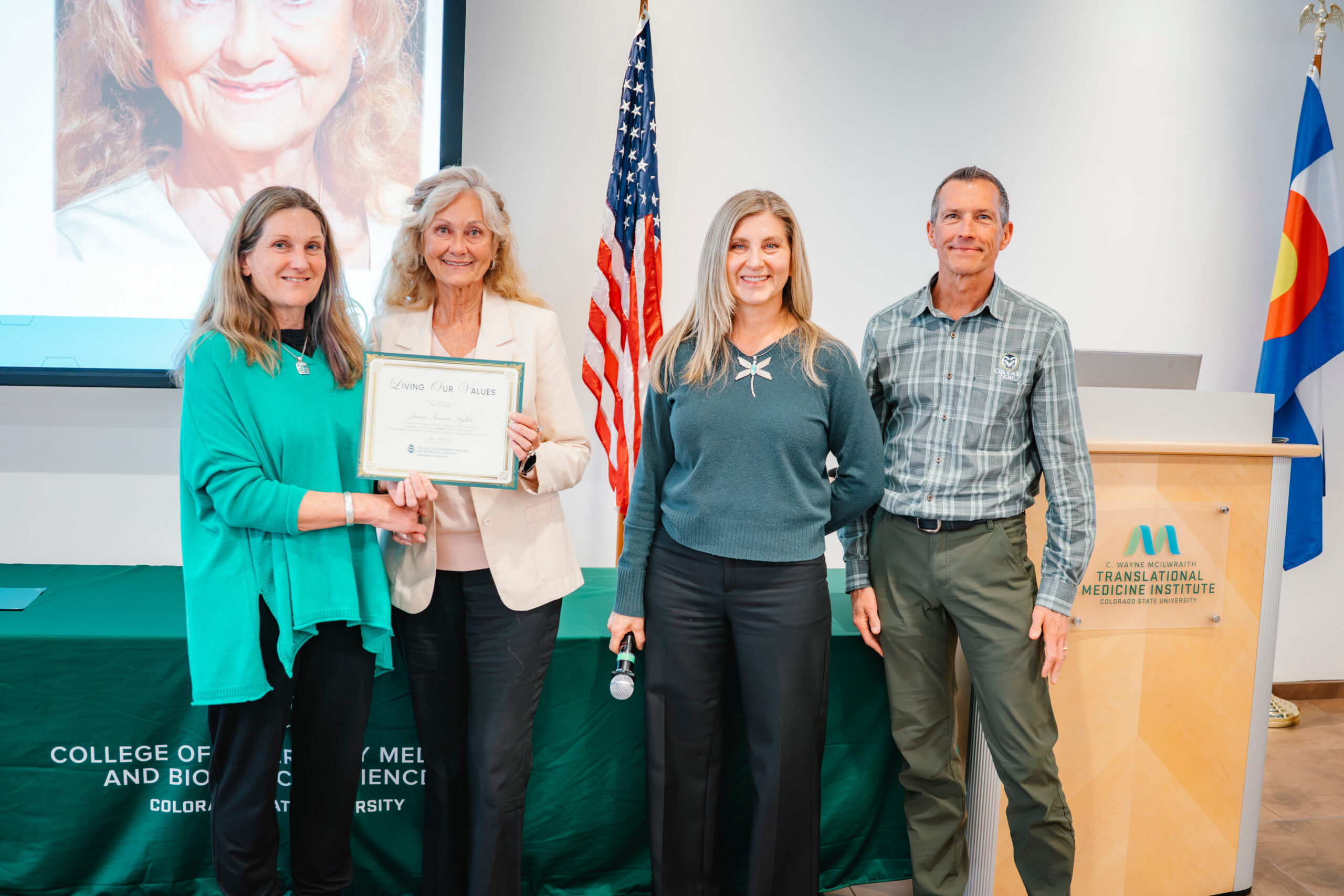 Janice Inman Leflet poses with her award certificate surrounded by three other faculty and staff members