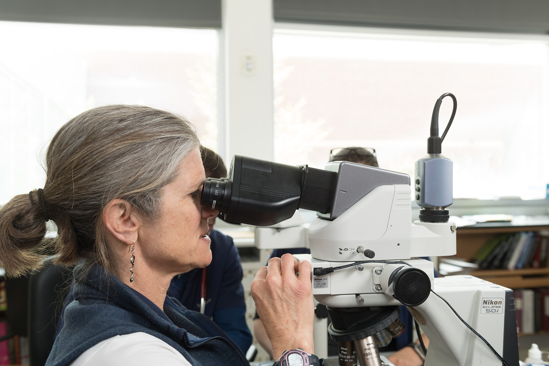 Dr. Christine Olver looking through a microscope