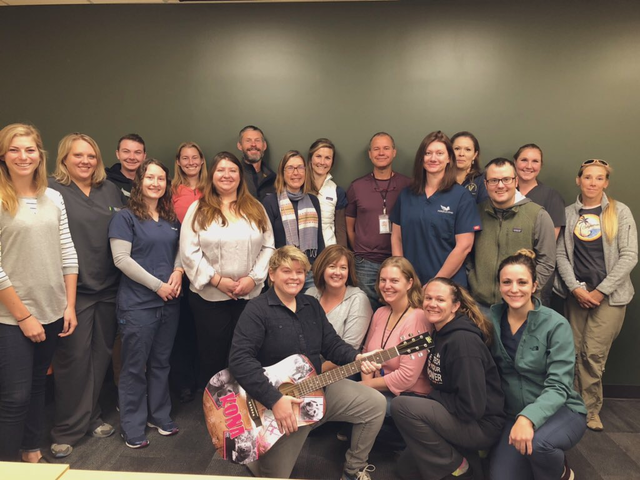 Amy Rodriguez in a room with colleagues smiling for a group photo